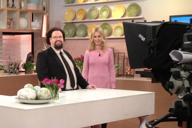 Edward Blom i tv-studio med påskdekorationer, tv-kamera i förgrunden